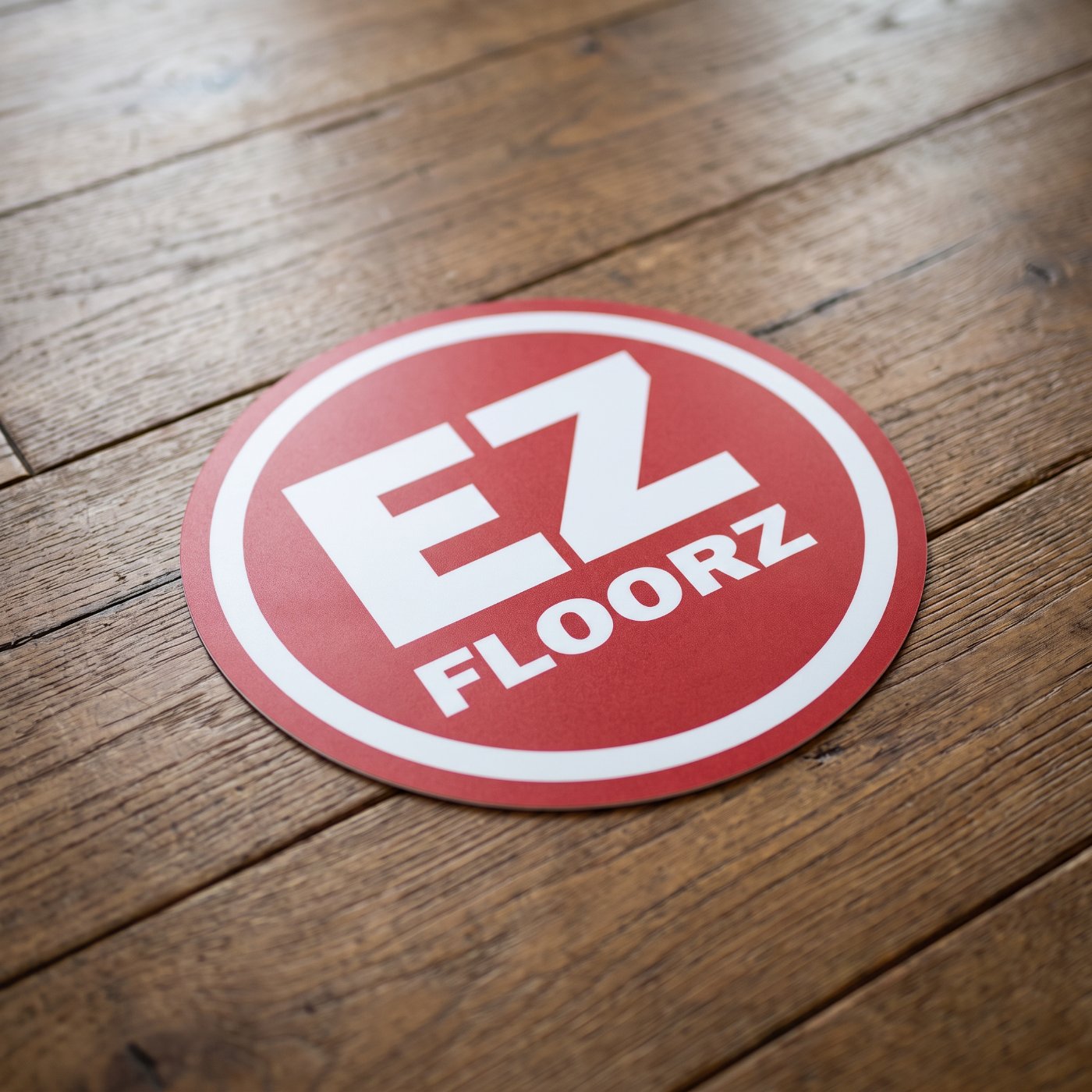 EZ Floorz branded logo displayed on rustic hardwood flooring