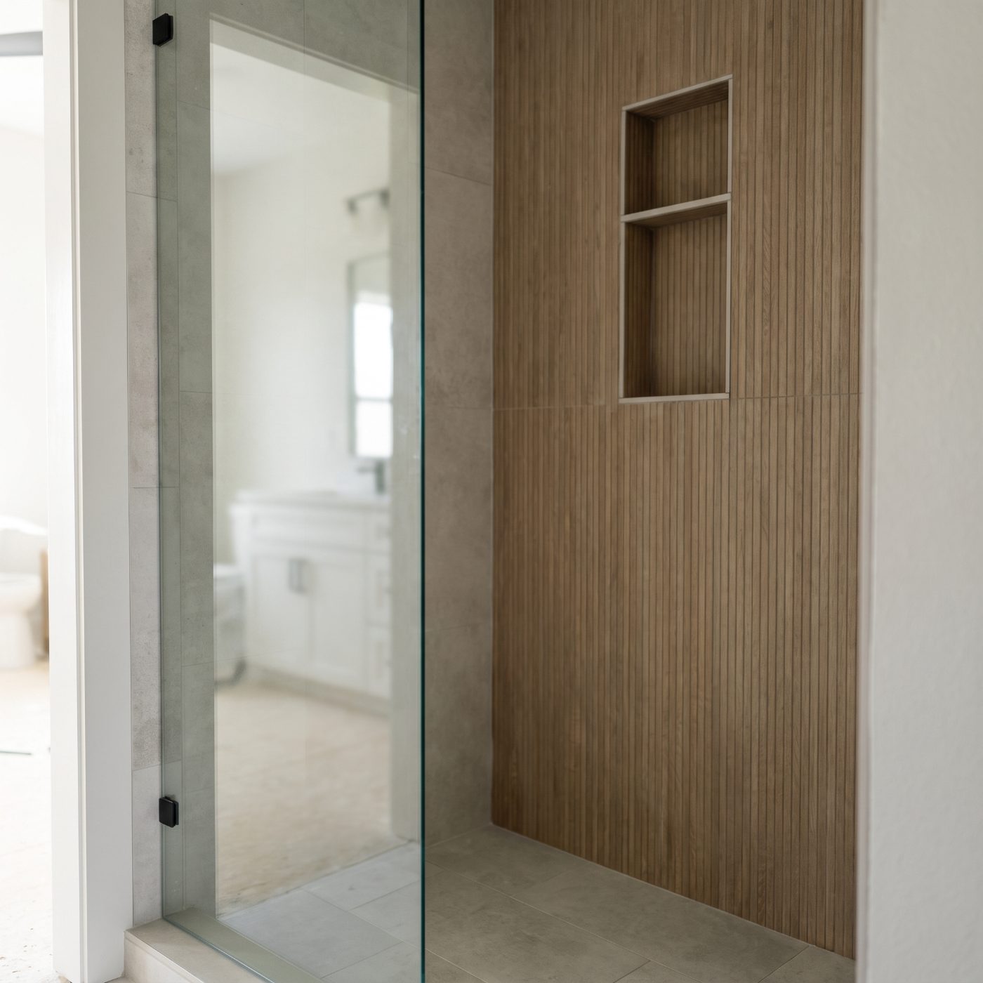 Modern bathroom with large-format stone tile floor and a glass walk-in shower